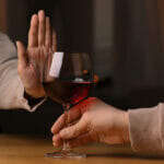 How To Come Clean To Your Family Member That You Have An Addiction Woman refusing to drink red wine indoors, closeup. Alcohol addiction treatment