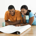 How To Use Home Improvement Loans To Add Value to Your Home African American male and female couple lying on floor looking a