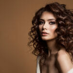 Everything You Need to Know About a Brown Wig Curly Hair Woman. Beauty Hairstyle Girl Over Dark Brown Backgrou
