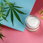 A Guide On CBD Topicals For Skin Irritation Dogs Hemp Face Cream In A Glass Jar, Two Cbd Oil Capcules And And Gre