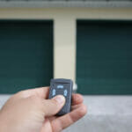 Expert Tips To Upgrade Your Garage The Man Holds In His Hand A Remote Control That Opens The Door O
