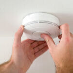 The Best Carbon Monoxide Detector Man installing smoke or carbon monoxide detector