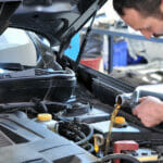 5 Vehicle Maintenance Tips Everyone Should Know Car mechanic changing oil - model and oil motion blurred.