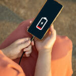 Close Up A Woman Sitting On Floor Hands Charging Her Smart Phone