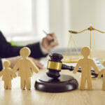 Gavel And Family Figures On Judges Table Illustrating Concept Of