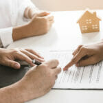 Hand of landlord, realtor pointing sign signature contract rental, purchase, buyer home or apartment with tenant, client after banker agreement mortgage, loan success or done. Property agent concept.