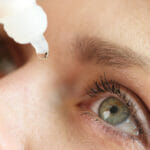 Caucasian woman using medical drops and dripping eye close up. Dry eyes syndrome, eye diseases and medical treatment concept.