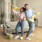 Strange But True Ways You Can Improve Your Singing Ability Happy Joyful Black Husband And Wife Tidying Home And Singing Dur