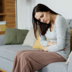 Why you should love your period. Sick Young Woman Suffering From Menstrual Pain. Woman With Hands