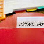 Mastering Income Tax Calculations: Your Expert Guide Income Tax – Crossed Out. Text On Paper Background. Financial Sa