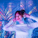 Relaxed Smiling Woman In White Clothes And Headphones Dancing In
