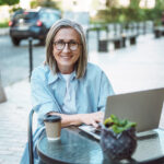 What Is a Digital Nomad Visa? Exploring Opportunities for Remote Work and Travel Working From Anywhere, Smiling And Happy Mature Woman Working On