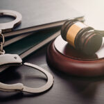 Facing Criminal Charges? You Don’t Have to Prove Your Innocence Handcuffs And Wooden Gavel. Crime And Violence Concept.