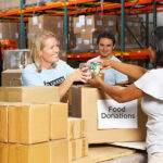 Volunteers Collecting Food Donations In Warehouse