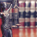 Lawyers desk, Scales of justice and law books on display.