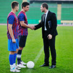 Kickstarting Careers: The Role of Football Business Academys in Sports Management Education soccer sport manager in business suit coach and football player