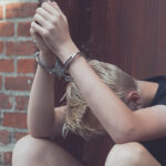 The Legal Framework for Youth Offenders in Canada For Sentencing and Reintegration Dejected Teenage Boy Held Captive In Handcuffs
