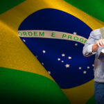 Student reading in library against digitally generated brazil na