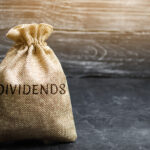 Money Bag With The Word Dividends. A Dividend Is A Payment Made