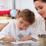 Top Tips for Integrating an Au Pair into Your Family Teacher watching her pupil coloring a drawing
