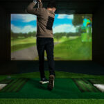 Young Golf Player Having Playing Video-game Golf Indoors