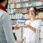 Innovative Medical Pharmacies: The Future of Healthcare Young Woman Pharmacist Giving Medications To The Male Client Sta