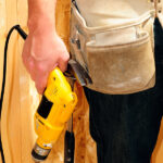 Contractor Wearing A Tool Belt And Holding A Power Drill