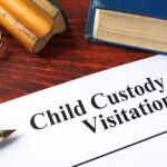 Child Custody and Visitation written on a paper and a book.