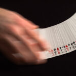 Tongits Go: Avoiding the Burn and Outsmarting Opponents Playing cards being spread on a black surface.