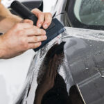 Car Wrapping Specialist Putting Vinyl Foil Or Film On Car. Prote