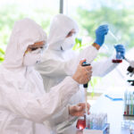 Understanding the Importance of Bloodborne Pathogen Safety Scientists In Protection Suits And Masks Working In Research Lab