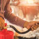 Close Up Hand Fireman Using Fire Extinguisher Fighting.
